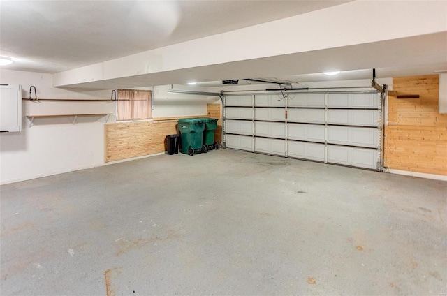 garage featuring a garage door opener and wood walls