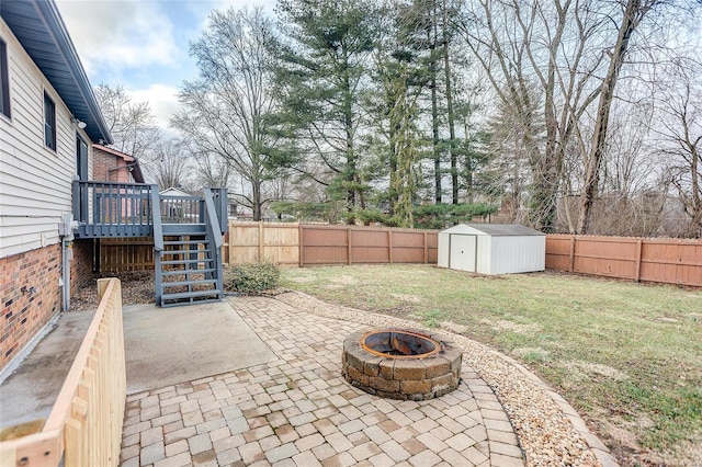 view of patio with a shed, a deck, and an outdoor fire pit