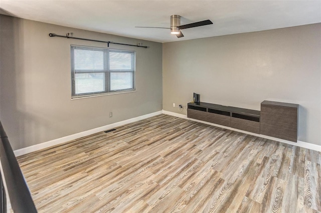 empty room with light hardwood / wood-style floors and ceiling fan