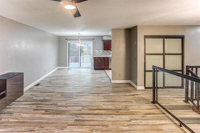 unfurnished living room featuring ceiling fan and light wood-type flooring