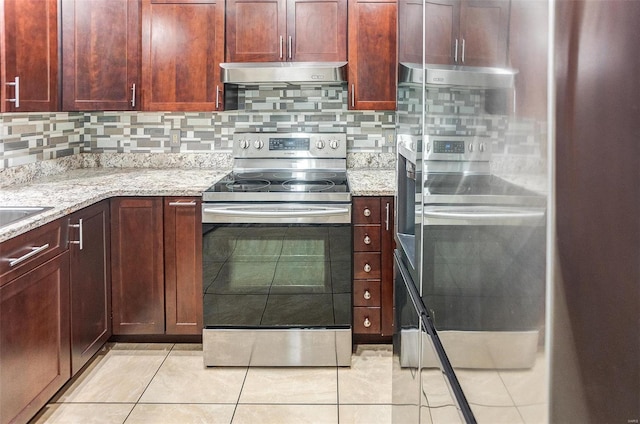 kitchen with light stone countertops, light tile patterned floors, stainless steel range with electric cooktop, and decorative backsplash