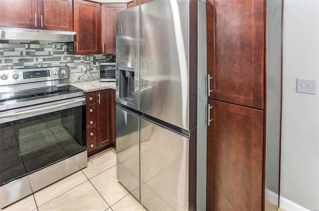 kitchen with light stone counters, appliances with stainless steel finishes, tasteful backsplash, and light tile patterned floors