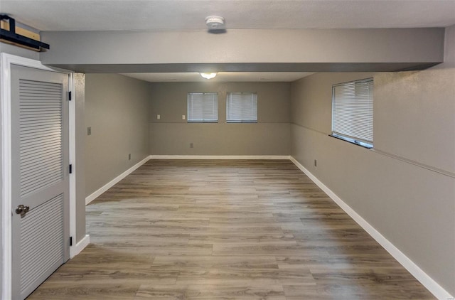 basement featuring a barn door and light wood-type flooring