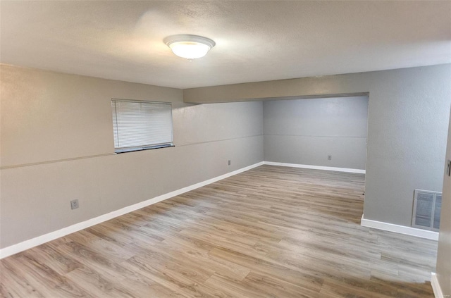 spare room with light hardwood / wood-style floors and a textured ceiling