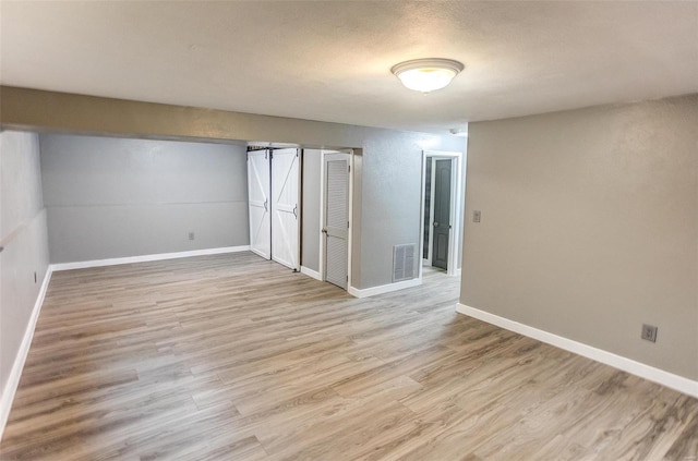 empty room with light hardwood / wood-style floors and a textured ceiling