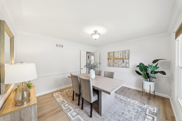 dining room featuring ornamental molding and light wood-type flooring