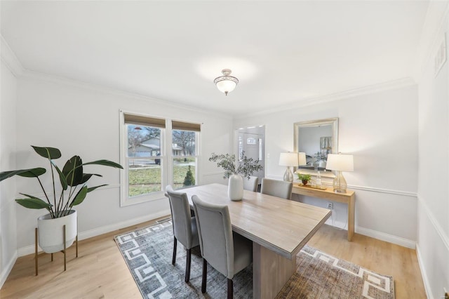 dining room featuring ornamental molding and light hardwood / wood-style flooring