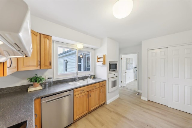 kitchen with sink, light hardwood / wood-style flooring, and appliances with stainless steel finishes