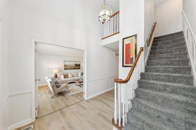 stairs featuring wood-type flooring and a high ceiling