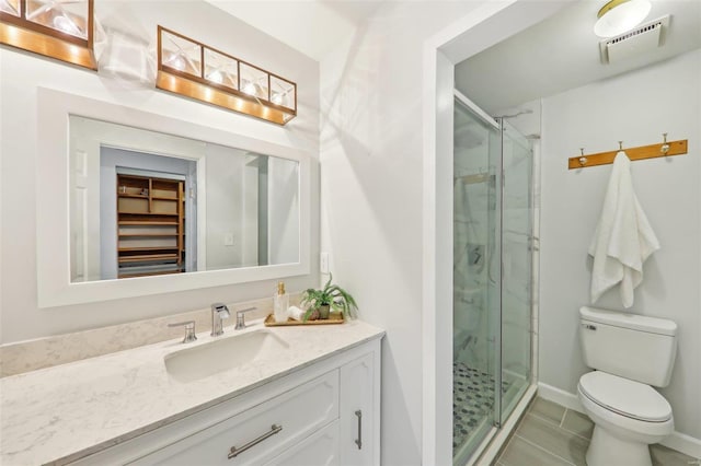 bathroom featuring vanity, toilet, a shower with shower door, and tile patterned flooring