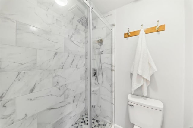 bathroom featuring a tile shower and toilet