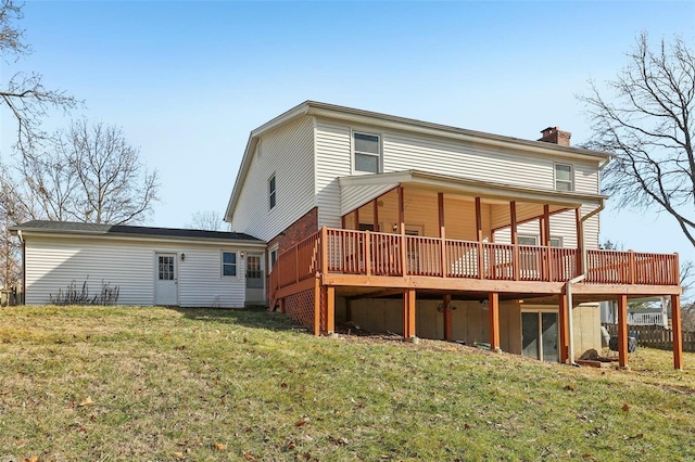 back of property with a wooden deck and a lawn