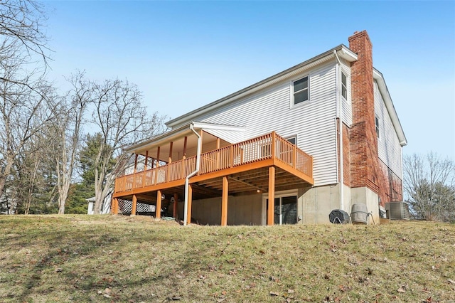 back of property featuring cooling unit, a yard, and a deck