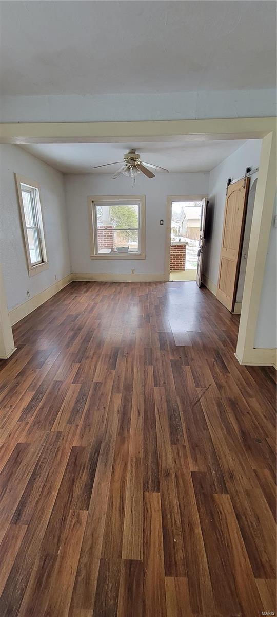 empty room featuring dark wood-type flooring and ceiling fan