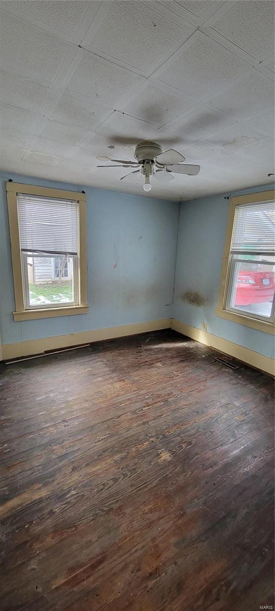 empty room with ceiling fan and dark hardwood / wood-style floors