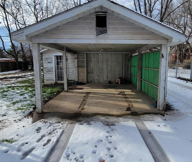 snow covered structure featuring a carport