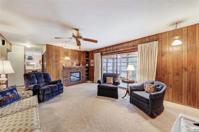 living room featuring a brick fireplace, light colored carpet, ceiling fan, and wood walls