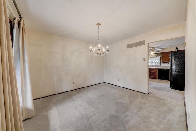 spare room featuring light carpet and a notable chandelier