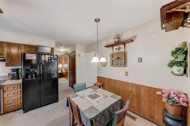 dining room with light carpet and wood walls