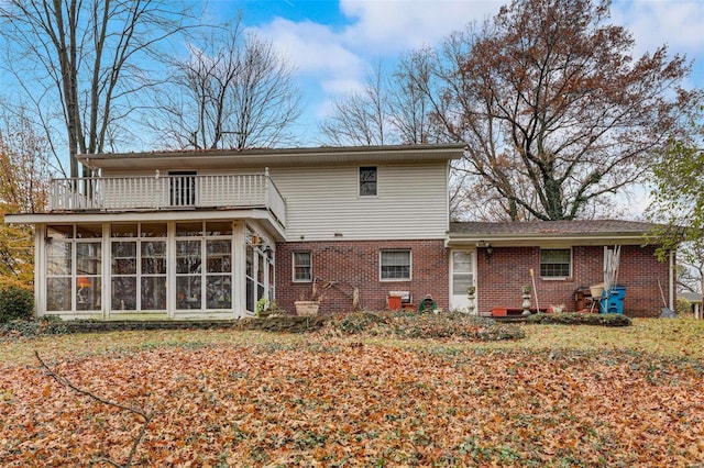 rear view of property with a balcony and a sunroom