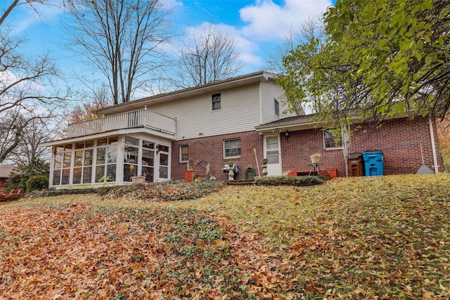 back of property with a sunroom and a balcony