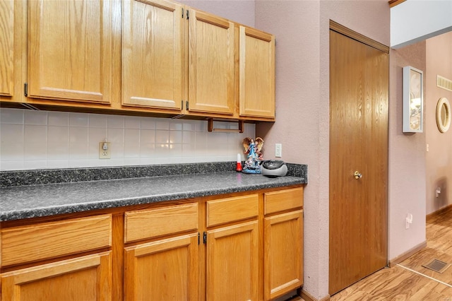 kitchen with decorative backsplash and light wood-type flooring