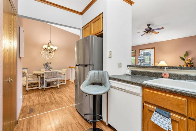 kitchen featuring sink, decorative light fixtures, stainless steel refrigerator, dishwasher, and light hardwood / wood-style floors