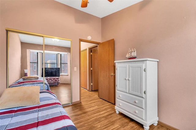 bedroom featuring light wood-type flooring, ceiling fan, and a closet