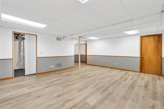 basement with light hardwood / wood-style floors and a drop ceiling