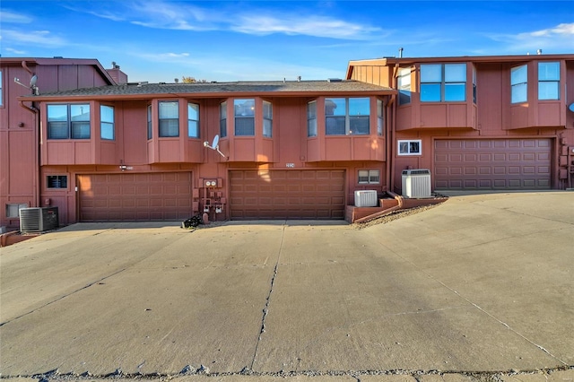 view of front of house featuring a garage and cooling unit