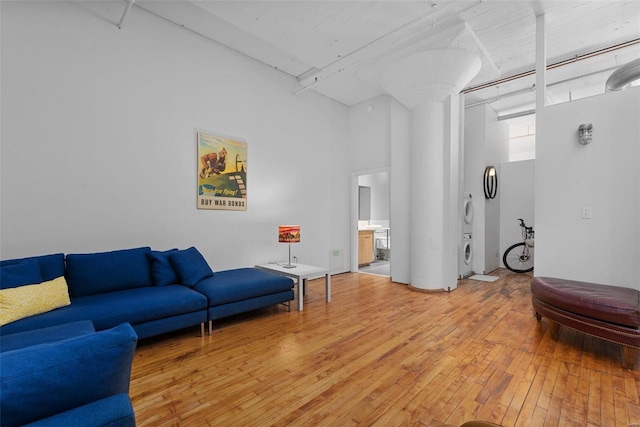 living room featuring stacked washer / dryer and light wood-type flooring