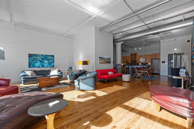 living room featuring hardwood / wood-style flooring and a towering ceiling