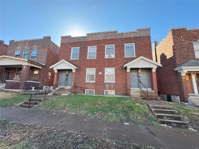 townhome / multi-family property featuring a front lawn