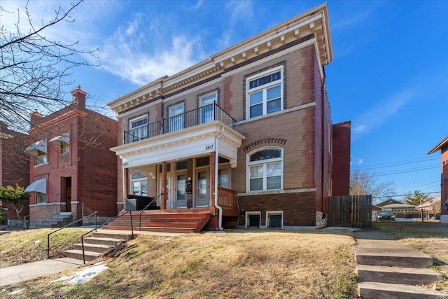 view of front facade with a front lawn, a balcony, and a porch