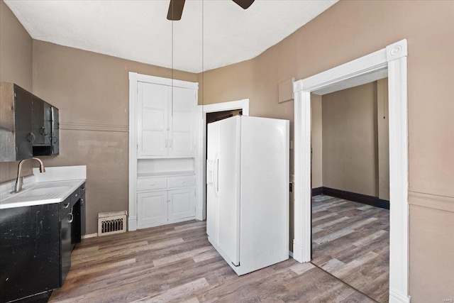 kitchen featuring ceiling fan, light hardwood / wood-style floors, white refrigerator with ice dispenser, and sink