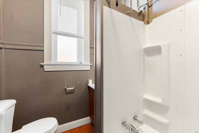 bathroom with vanity, wood walls, and toilet