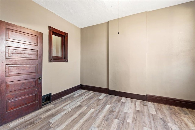 spare room with light hardwood / wood-style flooring and a textured ceiling