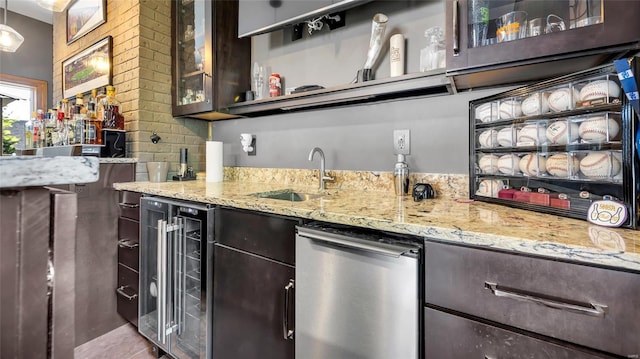 bar with decorative light fixtures, sink, beverage cooler, dark brown cabinetry, and light stone countertops