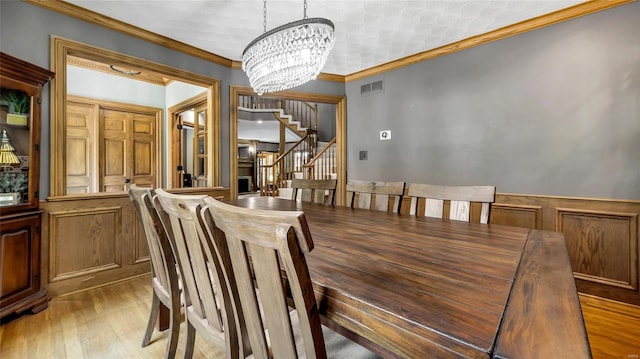 dining room featuring an inviting chandelier, hardwood / wood-style floors, and crown molding