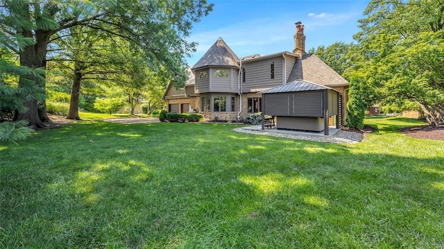 rear view of house featuring a gazebo and a yard