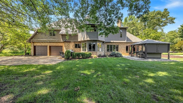 exterior space featuring a garage, a gazebo, and a yard