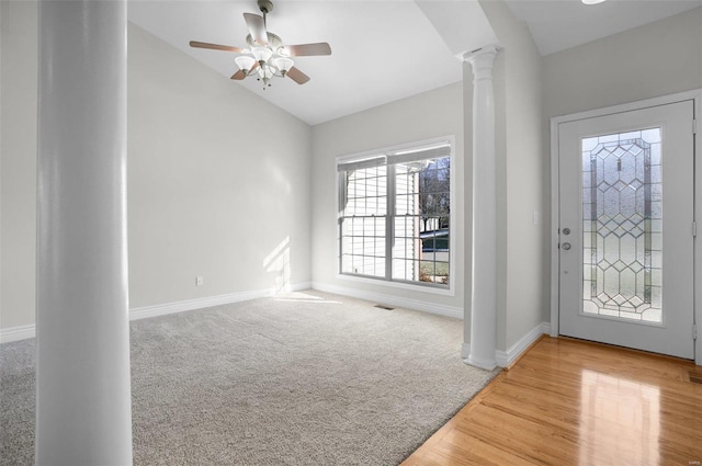 entrance foyer featuring ceiling fan, lofted ceiling, decorative columns, and carpet