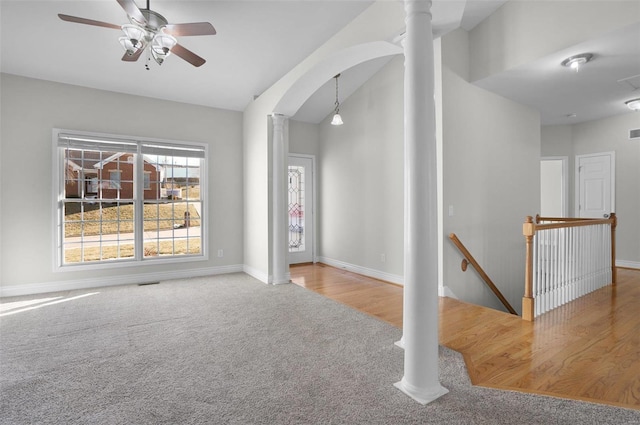 interior space with ceiling fan, high vaulted ceiling, carpet floors, and decorative columns