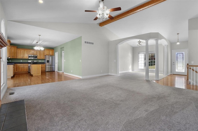 unfurnished living room with ceiling fan with notable chandelier, decorative columns, and light carpet