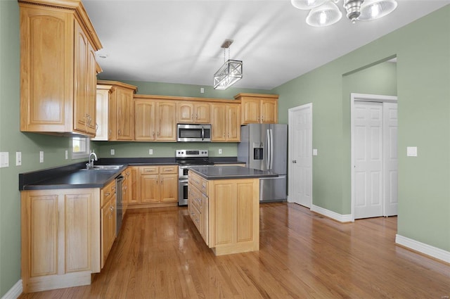 kitchen featuring light brown cabinetry, sink, a kitchen island, pendant lighting, and stainless steel appliances