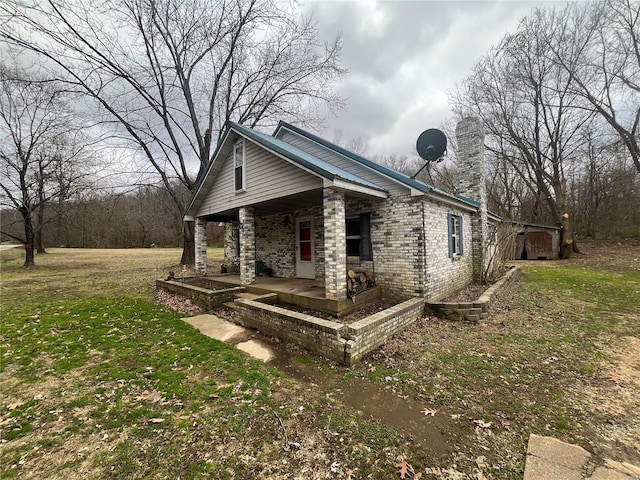 view of side of home with a yard and a porch