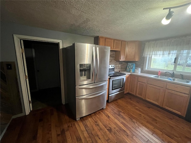 kitchen featuring sink, appliances with stainless steel finishes, dark hardwood / wood-style floors, a textured ceiling, and decorative backsplash