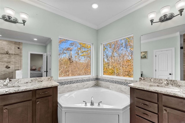 bathroom with ornamental molding, a bathing tub, and vanity