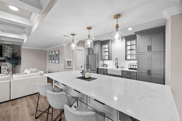 kitchen with pendant lighting, stainless steel appliances, gray cabinets, and sink