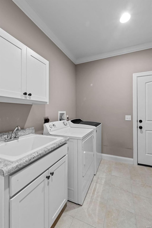 laundry room with light tile patterned flooring, sink, cabinets, ornamental molding, and washing machine and dryer